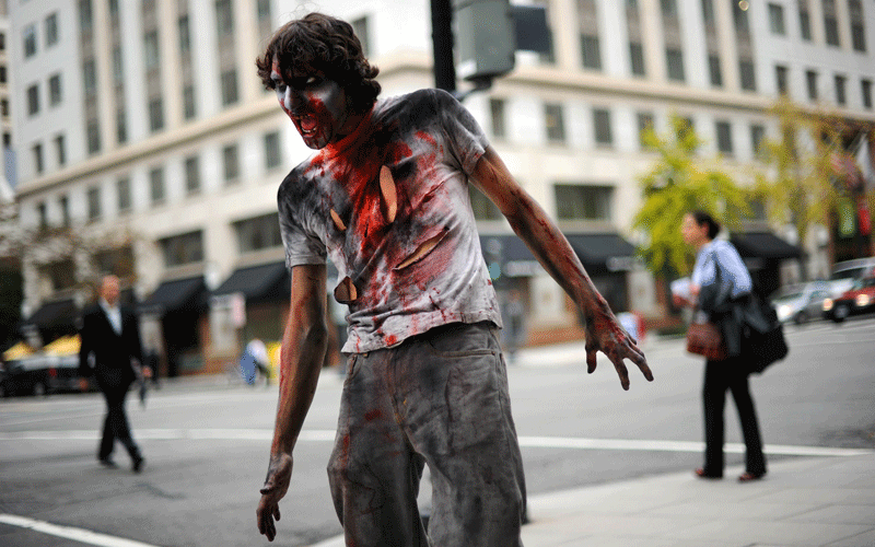 An actor portraying a zombie catches people off guard to promote the new TV series "The Walking Dead" on the AMC channel on October 26, 2010 outside the Metro Center subway entrance in Washington, DC. (AFP)