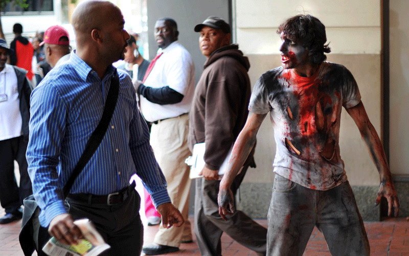 An actor portraying a zombie catches people off guard to promote the new TV series "The Walking Dead" on the AMC channel on October 26, 2010 outside the Gallery Place Metro entrance in Washington, DC. (AFP)