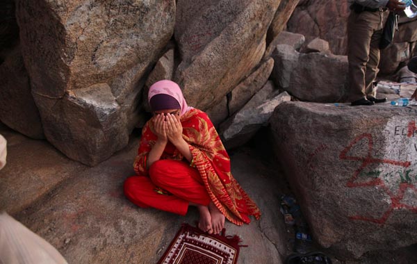 A Muslim pilgrim prays near the entrance of Hera cave on Mount Al-Noor during the annual haj pilgrimage in Mecca. (REUTERS)