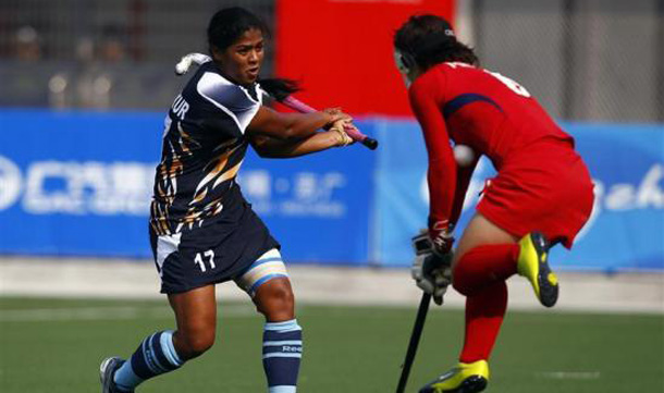 Japan's Keiko Manabe (R) stops a shot of India's Deepika during their preliminary women's field hockey game at the 16th Asian Games in Guangzhou, Guangdong province. (REUTERS)