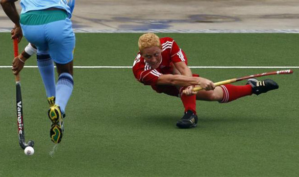 India's Sarvanjit Singh (L) tries to shoot past Hong Kong's Thomas Kieran Smith during their preliminary field hockey game at the 16th Asian Games in Guangzhou, Guangdong province. (REUTERS)