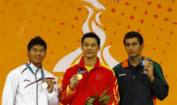 Gold medal winner Zhou Jiawei (C) of China stands with silver medal winner Masayuki Kishida (L) of Japan and bronze medal winner Virdhawal Vikram Khade of India during the medal ceremony for the men's 50m butterfly swimming event at the 16th Asian Games in Guangzhou, Guangdong province. (REUTERS)