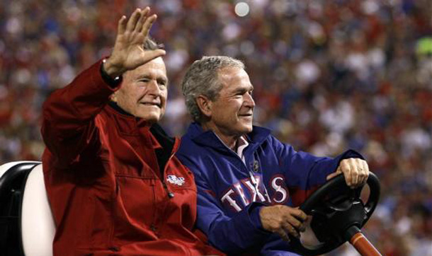 Former presidents George Bush and his son, George W. Bush, arrive to throw the ceremonial first pitch before Game 4 of the World Series in Arlington, Texas. (REUTERS)
