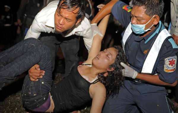 A Cambodian rescue team carries an unconscious woman near a bridge in Phnom Penh where hundreds of people were crushed during a stampede. (AFP)