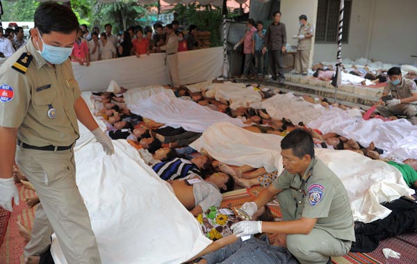 Cambodian police officials examine some of the victims of the overnight stampede at a hospital in Phnom Penh. (AFP)