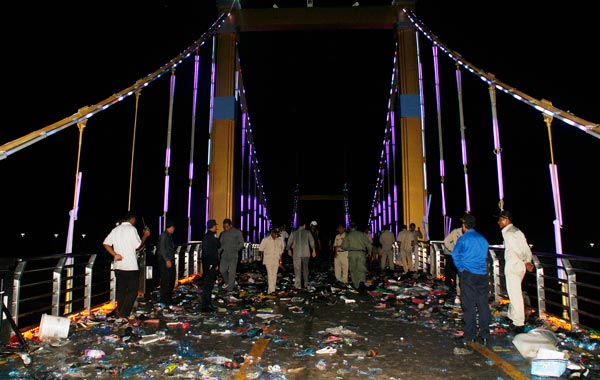 In this Nov. 23, 2010 photo released by China's Xinhua News Agency, Cambodian police officials examine the bridge where a stampede took place in Phnom Penh, Cambodia. (AP)