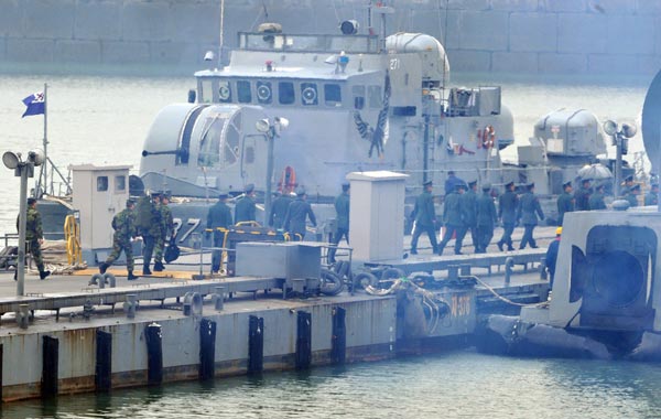 South Korean Marines walk along the dock onto a navy ship set to return to nearby Yeonpyeong island after it was shelled by North Korea the day before, at a harbour in Incheon, west of Seoul. (AFP)