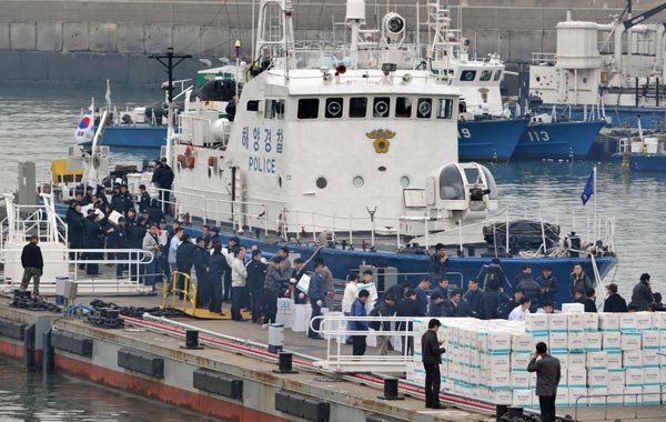 South Korean police officers move boxes of relief goods onto a boat bound for nearby Yeonpyeong island after it was shelled by North Korea the day before, at a harbour in Incheon, west of Seoul. (AFP)