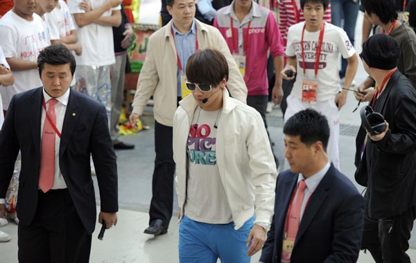 South Korean pop star Rain (C) is escorted by bodyguards after a last check of the stage a few hours before the beginning of the closing ceremony, during the 16th Asian Games in Guangzhou. (AFP)
