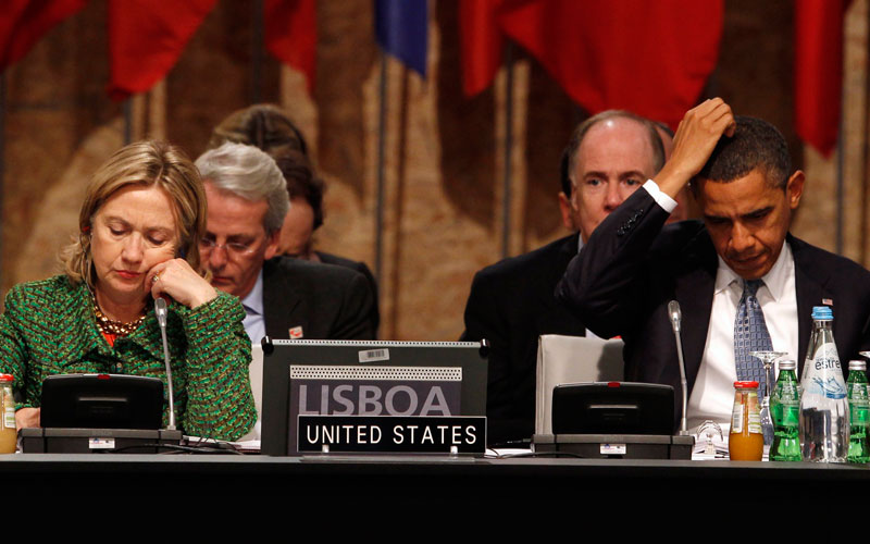 US President Barack Obama puts his hand to his head as he sits with Secretary of State Hillary Clinton during the Nato Summit in Lisbon November 19, 2010. (REUTERS)