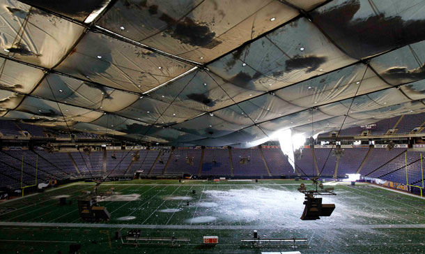 Snow falls into the field from a hole in the collapsed roof of the Metrodome in Minneapolis. The inflatable roof of the Metrodome collapsed Sunday after a snowstorm that dumped 17 inches (43 cms) on Minneapolis. No one was hurt, but the roof failure sent the NFL scrambling to find a new venue for the Vikings' game against the New York Giants. (AP)