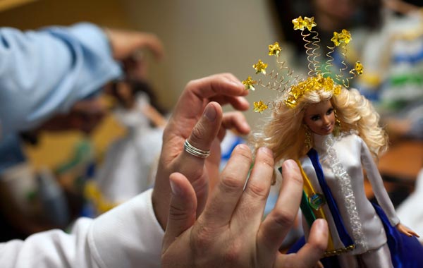 Contestant Johnny Fuentes (Unseen) changes the clothes of his Barbie doll "Shantal Martinez Gruber", before entering the Miss Barbie Venezuela 2010 beauty pageant as "Miss Guarico" in Caracas. (REUTERS)