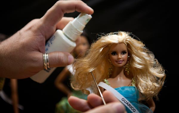 A contestant combs his Barbie doll, "Shantal Martinez Gruber" before entering the doll in the Miss Barbie Venezuela 2010 beauty pageant as "Miss Guarico" in Caracas. (REUTERS)