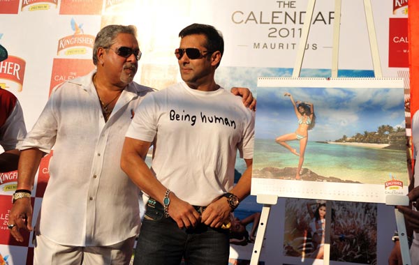 Indian Bollywood actor Salman Khan (R) and United Breweries group chairman Vijay Mallya (L) pose with calendar models during the launch of the 'Kingfisher Swimsuit Special Calendar 2011' in Mumbai. (AFP)