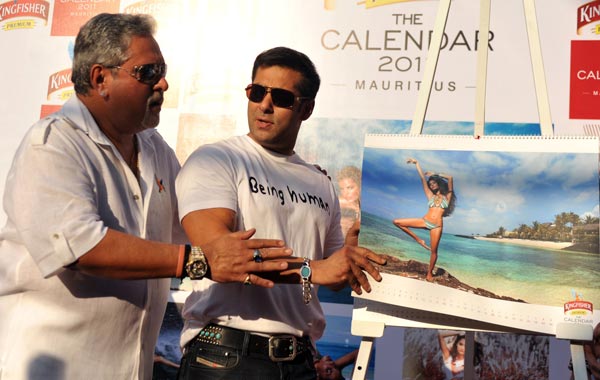Indian Bollywood actor Salman Khan (R) and United Breweries group chairman Vijay Mallya (L) pose with calendar models during the launch of the 'Kingfisher Swimsuit Special Calendar 2011' in Mumbai. (AFP)