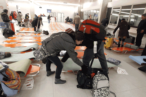 Passengers arrive to sleep on camp beds set up by rescuers from the French Protection Civile on December 19, 2010 at the Charles de Gaulle-Roissy airport, outside Paris, after some 40 per cent of flights were cancelled. (AFP)