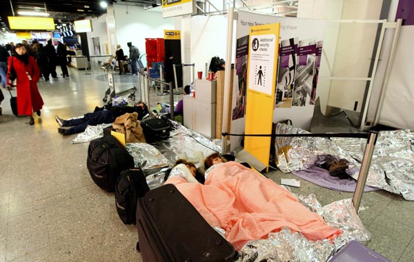 Passengers stranded after snow and ice forced the closure of runways are seen inside Terminal 3 at Heathrow Airport, London. (AP)