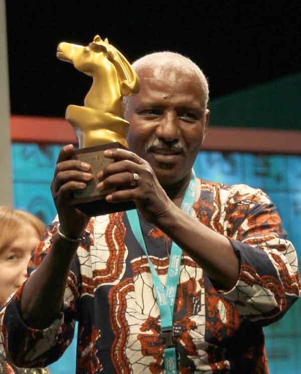 Chadian director Mahamat Saleh Haroun holds up the Muhr AsiaAfrica Feature Award for his movie 'The Screaming Man' during the closing ceremony of the Seventh Dubai International Film Festival (AFP)