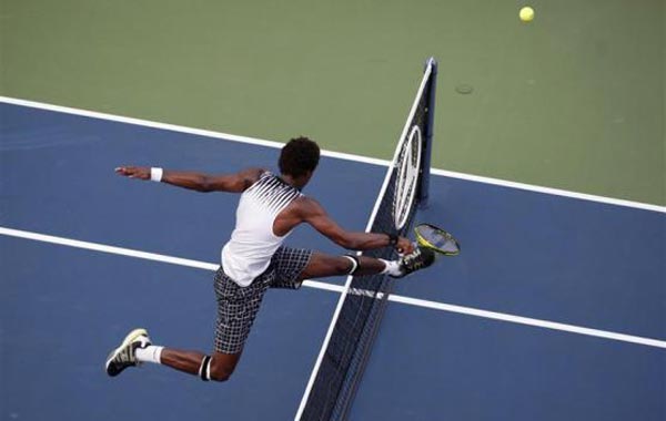 Gael Monfils of France jumps over the net after charging a ball at the net during his match against Igor Andreev of Russia at the U.S. Open tennis tournament in New York. (REUTERS)