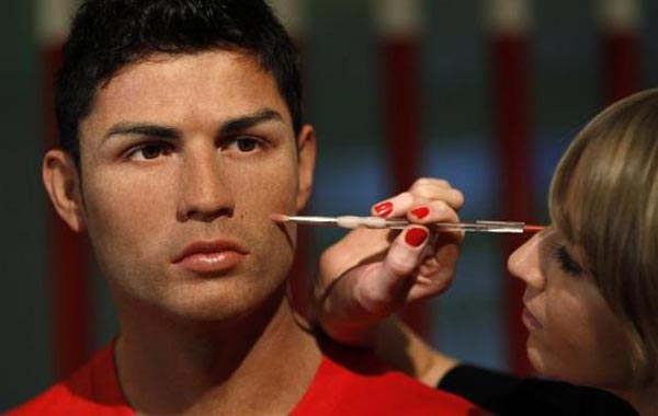 A sculptor poses with a wax figure of Portugal's soccer player Cristiano Ronaldo at Madame Tussauds in London. (REUTERS)