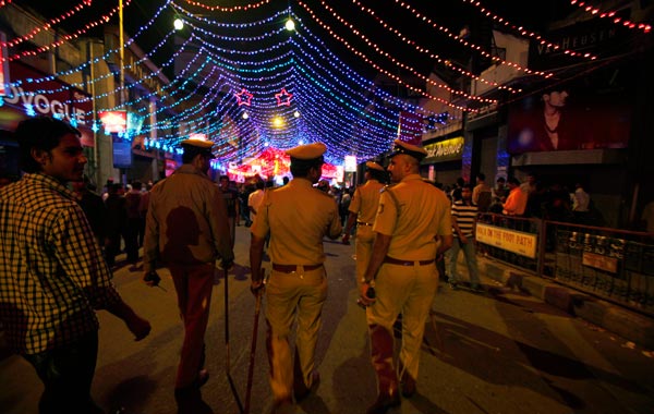 Police officials patrol a busy street on New Year's eve, in Bangalore, India. (AP)