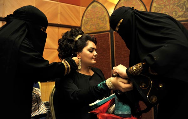 Saudi women put accessories on a model during a beauty and style competition on the sidelines of the 2010 Cosmetic Expo, a four-day exhibition held for the first time in Saudi Arabia, at a hotel in the coastal city of Jeddah. (AFP)