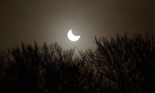 A partial solar eclipse is seen over trees in Studencice January 4, 2011. The partial eclipse will be visible near sunrise over most of Europe and northeastern Asia. (REUTERS)