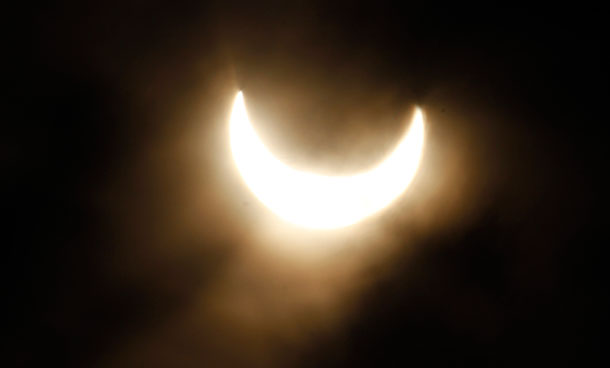 A partial solar eclipse is seen in the fog over the roofs in Vienna, Austria, on Tuesday, Jan. 4, 2011. (AP)