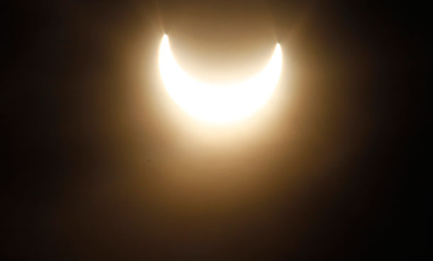A partial solar eclipse is pictured in the fog over the roofs in Vienna, Austria, on Tuesday, Jan. 4, 2011. (AP)