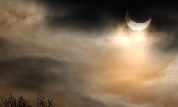 The moon passes between the sun and the earth during a partial solar eclipse in Munich January 4, 2011. (REUTERS)