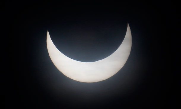 The moon passes between the sun and the earth during a partial solar eclipse in Munich January 4, 2011. (REUTERS)