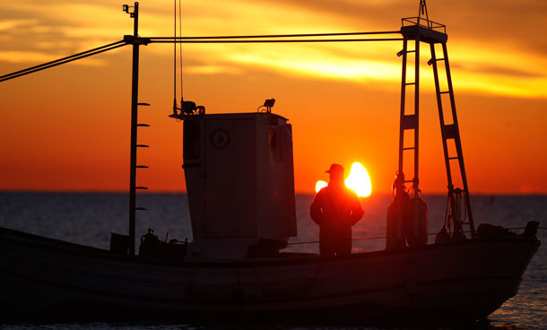 A fisherman is silhouetted against the sun at dawn during a partial solar eclipse near Guadalmar beach in Malaga January 4, 2011. The partial eclipse will be visible near sunrise over most of Europe and northeastern Asia. (REUTERS)