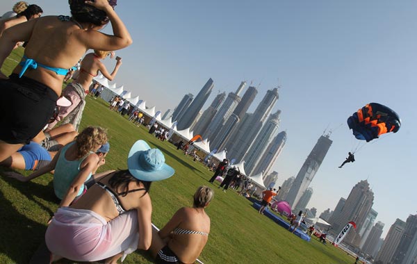 Foreign women watch as a member of the Belarus team lands in his parachute during Dubai's 2nd International Parachuting Championship and Gulf Cup 2011 in the Gulf emirate. (AFP)