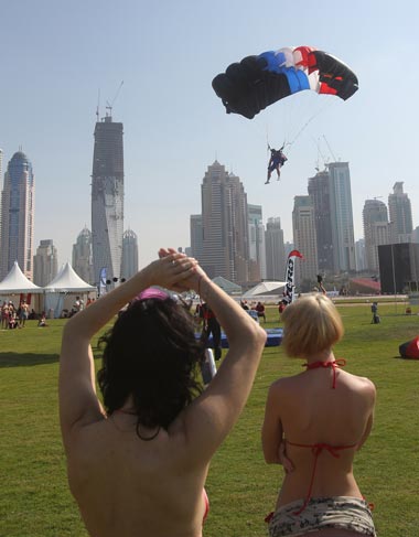 Foreign women watch as a member of the Armee Francaise team lands in his parachute during Dubai's 2nd International Parachuting Championship and Gulf Cup 2011 in the Gulf emirate. (AFP)