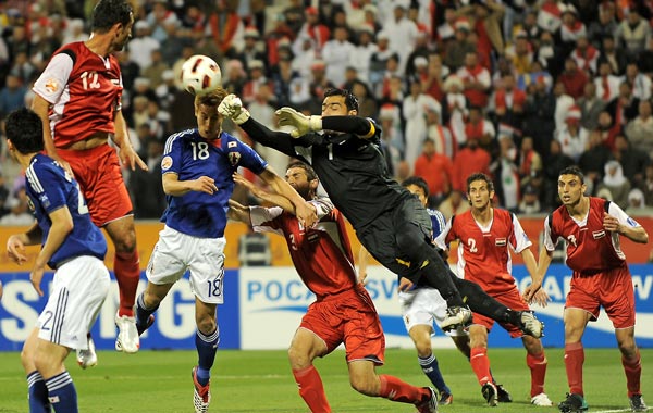 Syria's goalkeeper Mosab Balhus (C-R) jumps to catch the ball as Japan's midfielder Keisuke Honda (C-L) attempts to score during their 2011 Asian Cup group B football match at Qatar Sports Club Stadium in the Qatari capital Doha. (AFP)