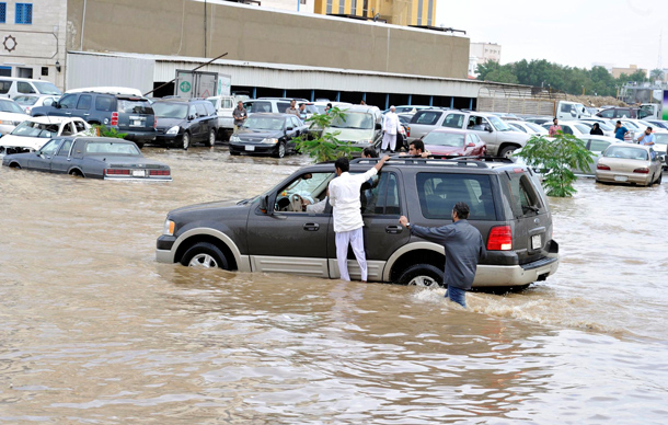 Men hang onto the sides of a car as it drives through a flooded street after heavy rainfall in Jeddah. Torrential rainfall submerged streets and cut off electricity in parts of Saudi Arabia's second largest city Jeddah on Wednesday, raising fears of a repeat of floods in 2009 which killed more than 120 people. (REUTERS)