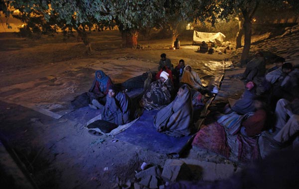 Homeless men watch a movie on a television outside a night shelter managed by an non-governmental organisation (NGO) in the old quarters of Delhi January 3, 2011. An intense spell of cold weather has forced hundreds of homeless to seek refugee in the shelters. Temperatures have dipped to 3.7 Celsius degrees (38.66 Fahrenheit) and reports say at least two people in the capital have died so far this winter. (REUTERS)