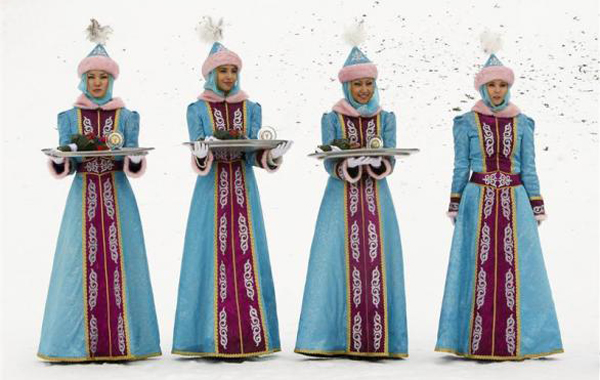 Women, dressed in Kazakh national costumes, hold medals during the award ceremony for the 7th Asian Winter Games men's freestyle skiing dual moguls qualification outside Almaty. (REUTERS)