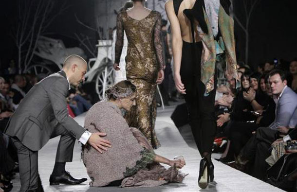 A model is helped by a spectator after she fell while presenting a creation by Georgian designer Irakli Nasidze during Georgian Fashion Week in Tbilisi, Georgia. (REUTERS)