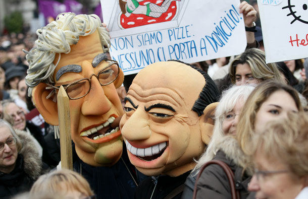 Protesters wearing masks of Renzo Bossi (L) and Silvio Berlusconi (R) during the National demonstration to appeal for greater dignity for Italian women at Piazza Castello in Milan, Italy. Thousands of women gathered this morning in many cities in Italy to demonstrate against the recent sex scandals surrounding Italian Prime Minister Silvio Berlusconi. (GETTY IMAGES)