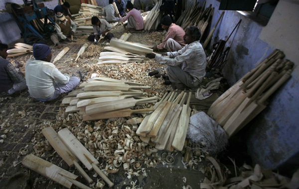 Workers file the edges of cricket bats to a smooth finish and fit cane sticks onto the handles at a factory in Meerut, 80 km (50 miles) northeast of Delhi. (REUTERS)