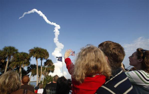 A youngster waves as space shuttle Discovery lifts off at the Kennedy Space Center in Cape Canaveral, Florida, February 24, 2011. (REUTERS)