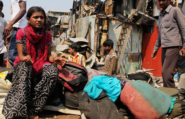 "Slumdog Millionaire" child star Rubina Ali sits outside her house with her belongings at a slum in Mumbai. (REUTERS)