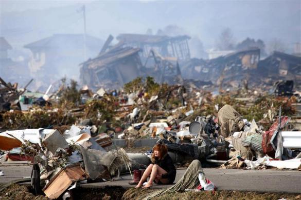 A woman cries while sitting on a road amid the destroyed city of Natori, Miyagi Prefecture in northern Japan March 13, 2011, after a massive earthquake and tsunami that are feared to have killed more than 10,000 people. (REUTERS)