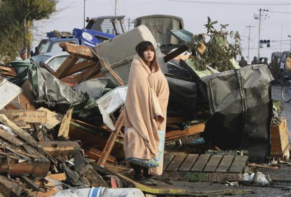 A woman looks at the damage caused by a tsunami and an earthquake in Ishimaki City, Miyagi Prefecture, after the magnitude 8.9 earthquake struck the area. (REUTERS)