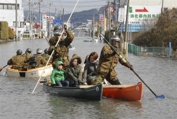 Self-Defense Force officers rescue people by a boat after a tsunami and earthquake in Ishinomaki City in Miyagi Prefecture. (REUTERS)