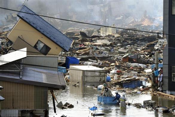 People, in a floating container, are rescued from a building following an earthquake and tsunami in Miyagi Prefecture, northeastern Japan. (REUTERS)