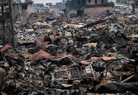 Rescue workers search through rubble in an area hit by an earthquake and tsunami in Otsuchi March 15, 2011. In the town of Otsuchi in Iwate prefecture, 12,000 out of a population of 15,000 have disappeared following Friday's massive earthquake and tsunami. (REUTERS)