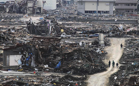 People walk on a makeshift dirt road among the rubble in Minamisanrikucho, northern Japan, Monday, March 14, 2011, three days after a powerful earthquake-triggered tsunami hit the country's east coast. (AP)