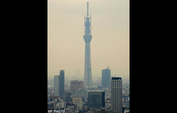 Construction workers are visible on Tokyo Sky Tree, a new landmark tower which is still under construction in Tokyo. The old Tokyo Tower remains one of the city's most visible landmarks and is visited by about 3 million tourists each year, even though it now competes with a plethora of other skyscrapers. (AP)